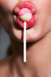 © Volodymyr - Close up of model sucking a pink and white lollipop
