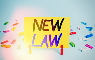 Conceptual hand writing showing New Law. Concept meaning system of rules that enforced through social or governmental Colored clothespin rectangle shaped paper blue background