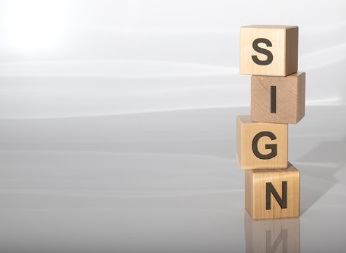 Word SIGN on wooden cubes on grey white glossy background