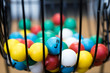 A close up of a bingo cage filled with multi-colored balls. Each ball has a letter and number on it that corresponds to a number on the player's bingo card. Bingo is a game of chance.