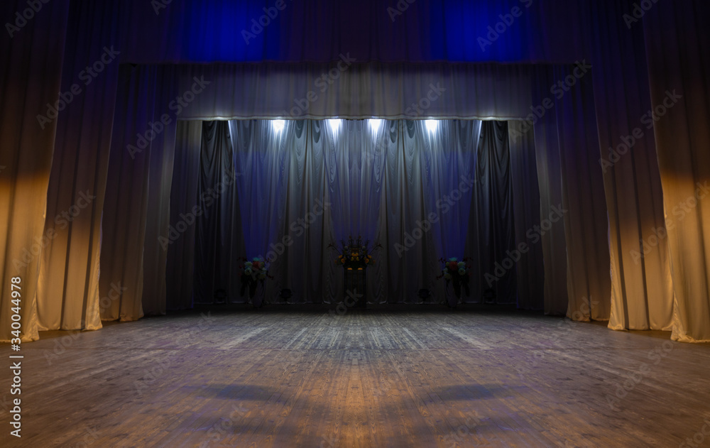An empty stage of the theater, lit by spotlights before the performance - obrazy, fototapety, plakaty 