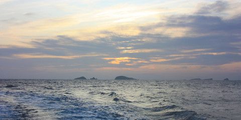 Wall Mural - romantic blue sunset between the waves of the Mediterranean sea and the islets of Ibiza on the horizon