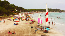 Sandy Beach Crowded With Ses Salines In Ibiza And Bathers By The Sea In Summer On The Shoreline