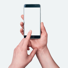 Female hands holding a smartphone on white background, index finger taps on screen