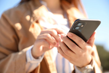 MYKOLAIV, UKRAINE - MARCH 16, 2020: Woman holding iPhone 11 Black outdoors, closeup