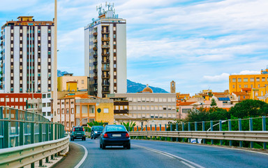 Canvas Print - Cars on summer road in Olbia city on Sardinia reflex