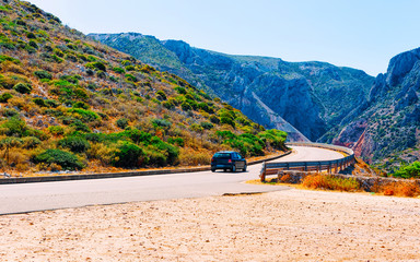 Canvas Print - Scenery with car on highway in Cagliari in Sardinia hills reflex