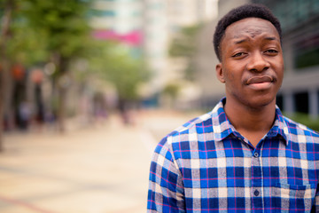 Wall Mural - Young handsome African man exploring the city