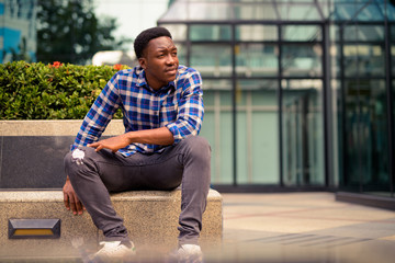 Wall Mural - Young handsome African man exploring the city