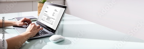 Fotomural Businesswoman Checking Invoice On Laptop