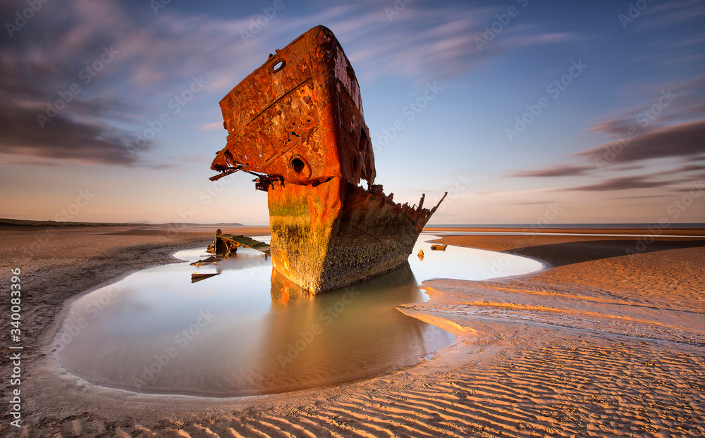 An old shipwreck boat abandoned stand on beach or Shipwrecked off the coast of Ireland - obrazy, fototapety, plakaty 