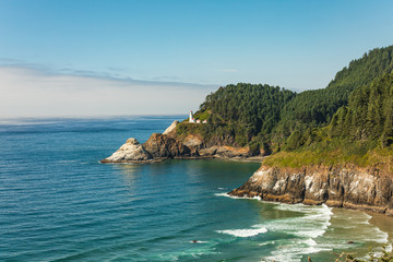 Wall Mural - Beach and cliffs leading to Heceta Head Lighthouse as seen from overlook with fog bank offshore.
