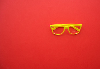 Wall Mural - yellow glasses on a red background