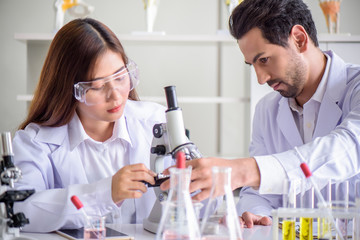 Wall Mural - attractive happiness scientist lab technician assistant analyzing sample in test tube at laboratory.