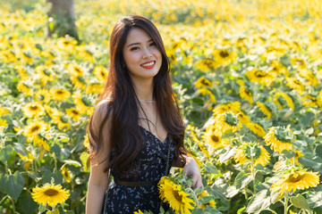 Wall Mural - asian cute young woman joyful, smiling with sunflowers background.
