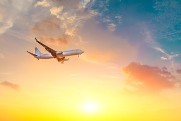 Commercial airplane flying in beautiful sky at sunset,travel concept.