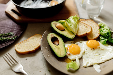 Wall Mural - Healthy breakfast: scrambled eggs, toast, avocado, lettuce, rosemary
