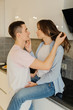 © deineka - Smiling, loving young couple in the kitchen having a great time together. Relationship concept.