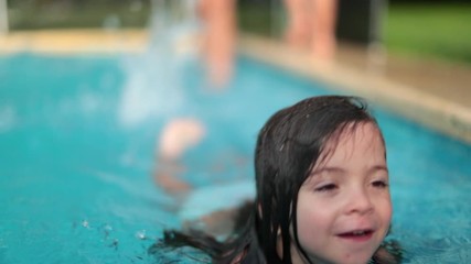 child girl swimming at pool during summer day. cute adorable small girl playing and splashing water