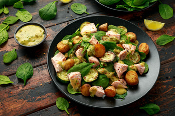 Wall Mural - Salmon, new potato, courgette and spinach salad on wooden table