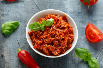 Sun dried tomato pesto in white bowl.