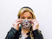 Young Blonde Caucasian Woman Wearing Colorful Face Mask Made Of Fabric Isolated Infront Of White Background