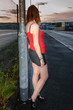 Woman dressed as a prostitute standing against a lamppost