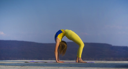 Young gymnast girl perform various gymnastic and yoga exercises, including splits and bending over backwards in front of the camera.