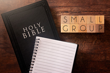 Poster - Small Group in Block Letters on a Wooden Table with a Holy Bible