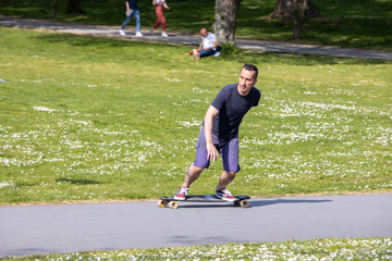 Man riding a skateboard at German park in sunny day