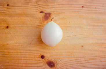 Peeled onion on a cutting board. Layout with text space, top view