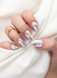 Woman's hand with fashionable nails holding fabric
