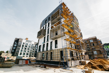 
construction site of residential buildings with cranes in sunny weather with blue sky