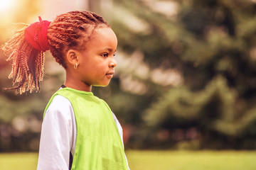 Wall Mural - A close portrait of a young African girl with a background of nature	