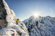 An alpinist climbing a steep ice, snow and rock face in alpine like mountain landscape of High Tatras, Slovakia. Winter extreme mountaineering and alpinism on alpine peaks. Sunset over a climber.