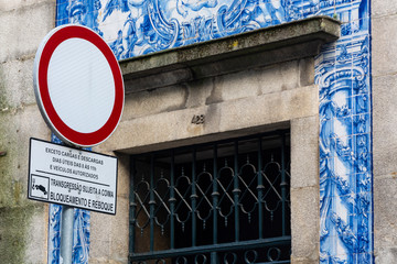 Prohibitory traffic sign with blue building in the background. Traditional portuguese tiles. Porto