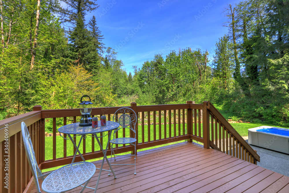 SImple wooden deck with metal chairs and table overlooking wild nature Northwest forest and swamp land. - obrazy, fototapety, plakaty 