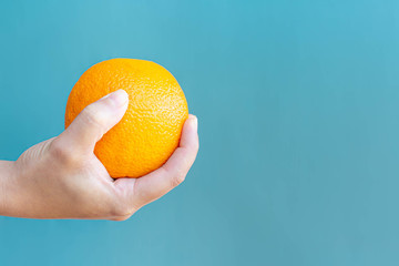 A woman holding a orange fruit. Healthy eating.