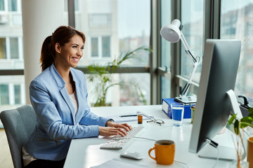 Wall Mural - Happy businesswoman working on a computer in the office.