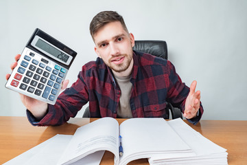 The man looks at the camera and shows the calculator. Fair price. Error in calculations. Cheating the customers. The auditor found errors. Negligence. Scam.