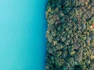 Aerial dron shot of  lake with turquoise, crystal-clear  water and forest. Pomerania, Poland, lake Radunskie.