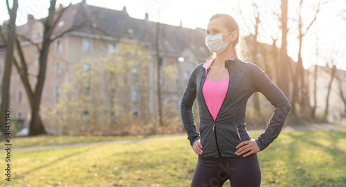 Cuadros en Lienzo Fit woman during health crisis exercising outdoors wearing mask