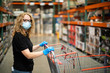 © Ursula Page - A woman shopping for groceries and necessities for her family inside a warehouse-style store during the pandemic Covid-19 coronavirus pandemic and she is wearing a face mask and latex rubber gloves