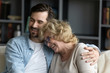 © fizkes - Close up of grown up child son hugs elderly mother family sit on couch enjoy talk funny conversation laughing, remember life, share positive news feels happy spend time together, family bonds concept