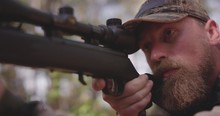 Close Up Of Man Hunting In Woods With Rifle