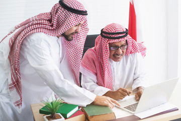 Wall Mural - Two Arab business man working on laptop computer, discussing project in laptop at meeting