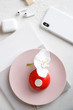 red mousse cake on a pink plate with orchid and smartphone