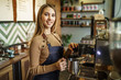 © Тарас Нагирняк - Portrait of young cute girl, barista steaming milk at the modern coffee shop