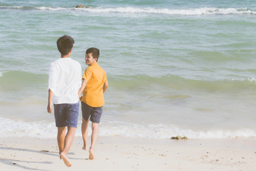 Homosexual portrait young asian couple running with cheerful together on beach in summer, asia gay going tourism for leisure and relax with happiness in vacation at sea, LGBT legal concept.