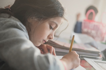 Wall Mural - Seven years old girl doing homework at home